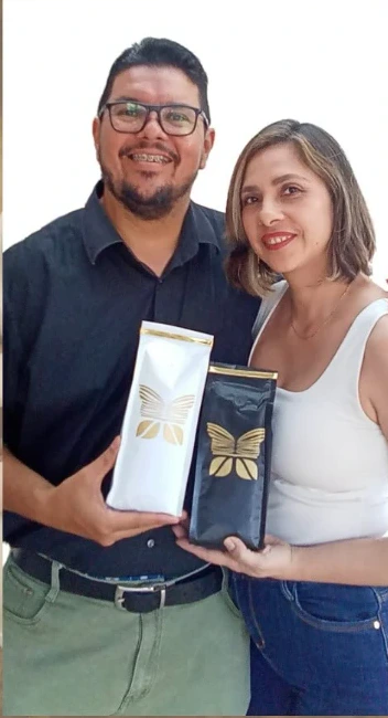 Los fundadores de Gabo Café sosteniendo dos bolsas de café con la mariposa dorada
